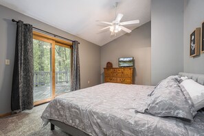 A bedroom with a bed, a dresser, a ceiling fan, and a TV. - Misty Creek by Taylor Made Deep Creek (McHenry)