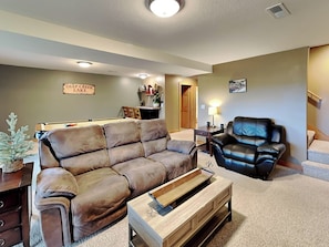 A living room with a brown leather couch, a black leather chair, and a wooden coffee table. - Mountain Dreams by Taylor Made Deep Creek (McHenry)