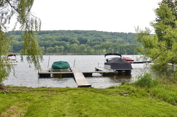 A lakeside dock with boats and a grassy area.