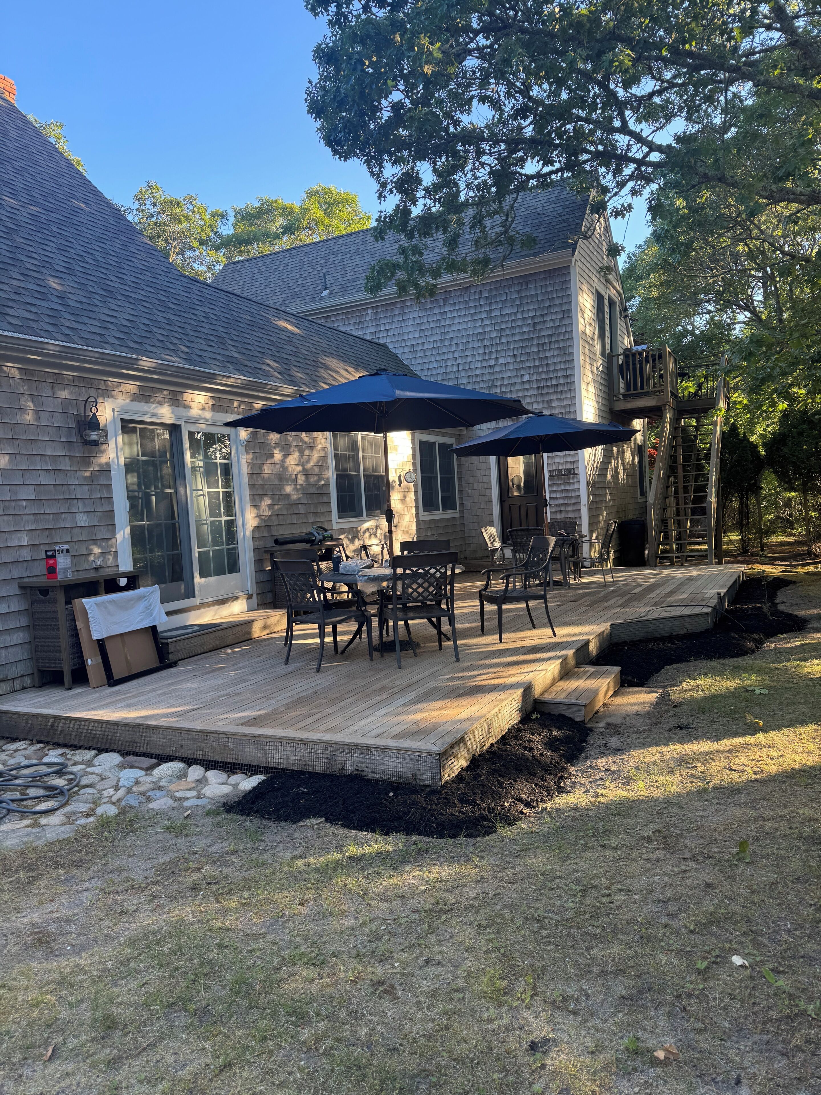 A house with a deck, outdoor furniture, and a covered patio area.