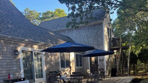 A house with a deck, outdoor furniture, and a covered patio area. -  BRAND NEW KITCHEN! CLOSE TO DOWNTOWN EDGARTOWN AND THE BEACH! (Edgartown)