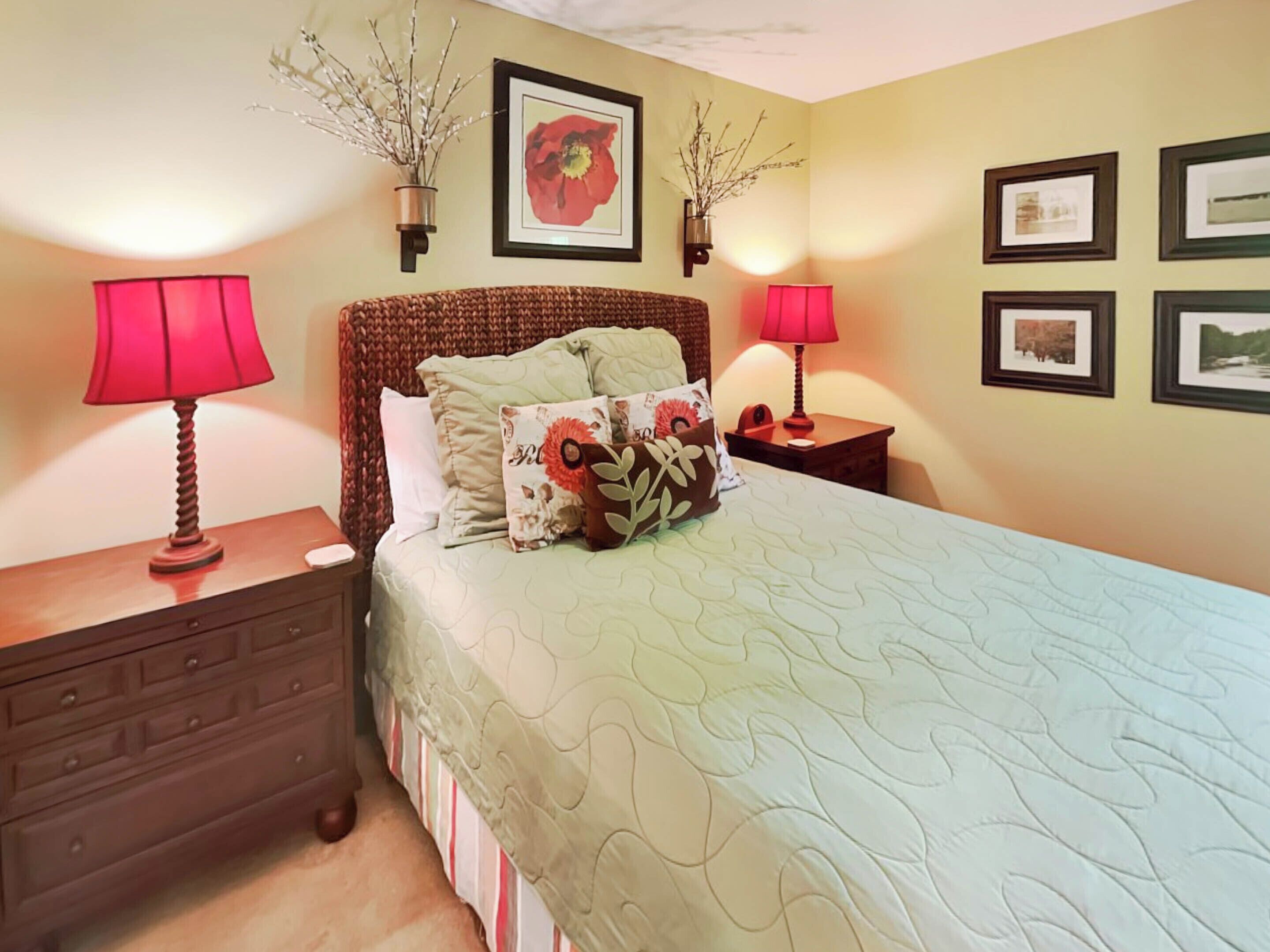 A neatly arranged bedroom with a bed, two bedside tables, a dresser, and wall-mounted lamps.