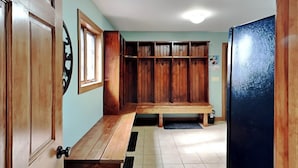 A kitchen with wooden cabinets, a wooden bench, a refrigerator, and a window. - Mountainlair by Taylor Made Deep Creek (McHenry)