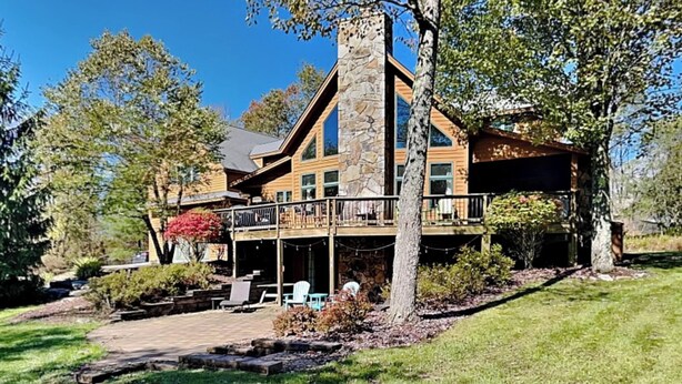 A large, two-story stone building with a balcony and outdoor seating area. - Mountainlair by Taylor Made Deep Creek (McHenry)