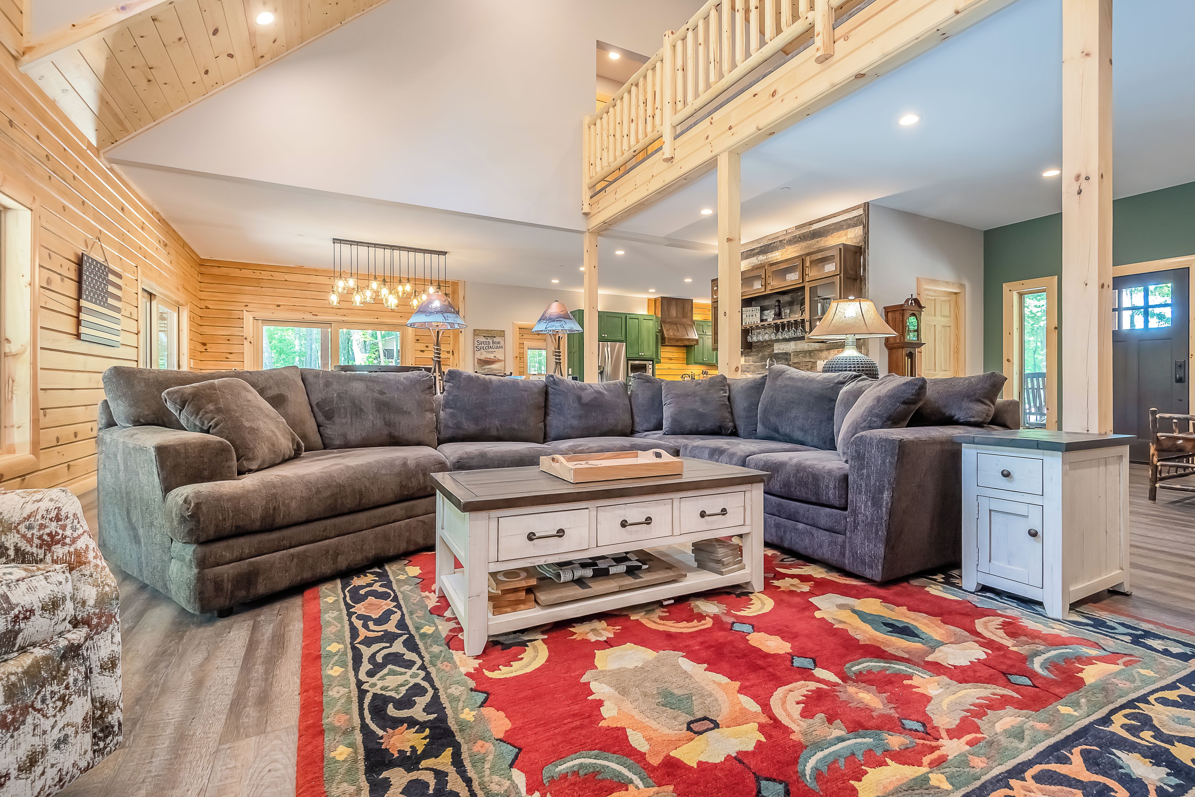 A spacious living room with a large sectional sofa, a coffee table, and a patterned rug.