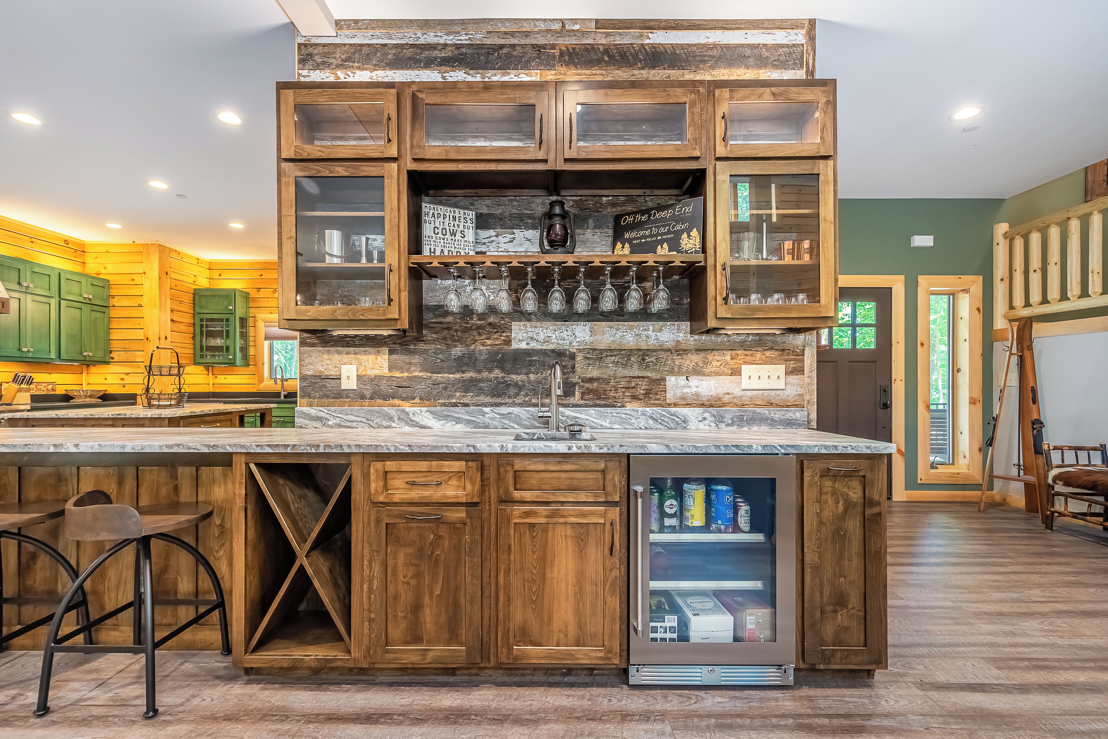 A kitchen with wooden cabinets, a marble countertop, and a built-in refrigerator.