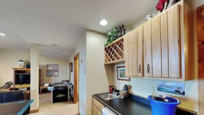 A compact kitchen with wooden cabinets, a sink, and a countertop.