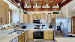 A kitchen with wooden cabinets, a stainless steel refrigerator, a microwave, and a dishwasher.
