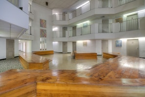 Enjoy a communal space with a central open area, wooden benches, and patterned floor.