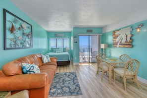 Relax in a serene space with a comfortable bed, sofa, and ocean view.