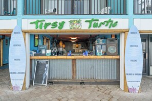 Fachada de loja com placa indicando 'Tippy Turtle' e pranchas de surf de ambos os lados.