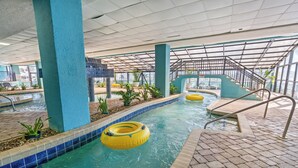 Una piscina interior con agua cristalina, flotadores de juguete amarillos y suelo de baldosas.