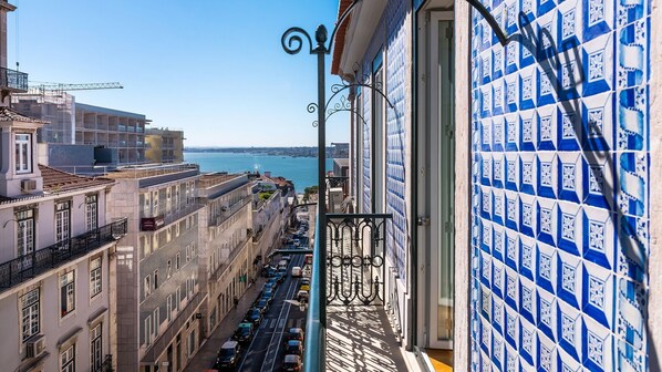 A high-rise building with a view of the sea and a tiled wall with a geometric pattern.