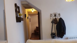 A cozy room with a wooden bench, a small table, and a hanging light fixture. - Cottage (Tózar)