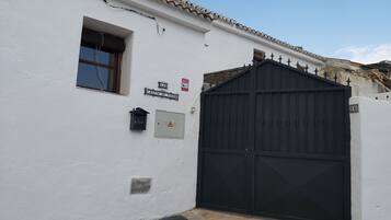 Un bâtiment blanc avec une porte noire, une fenêtre et une boîte aux lettres.