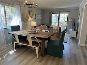 Uma sala de jantar com mesa de madeira, cadeiras e um candelabro.