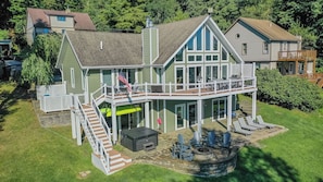 A two-story house with a balcony, a deck, and a fire pit area. - Ski to Shore Chalet by Taylor Made Deep Creek (McHenry)