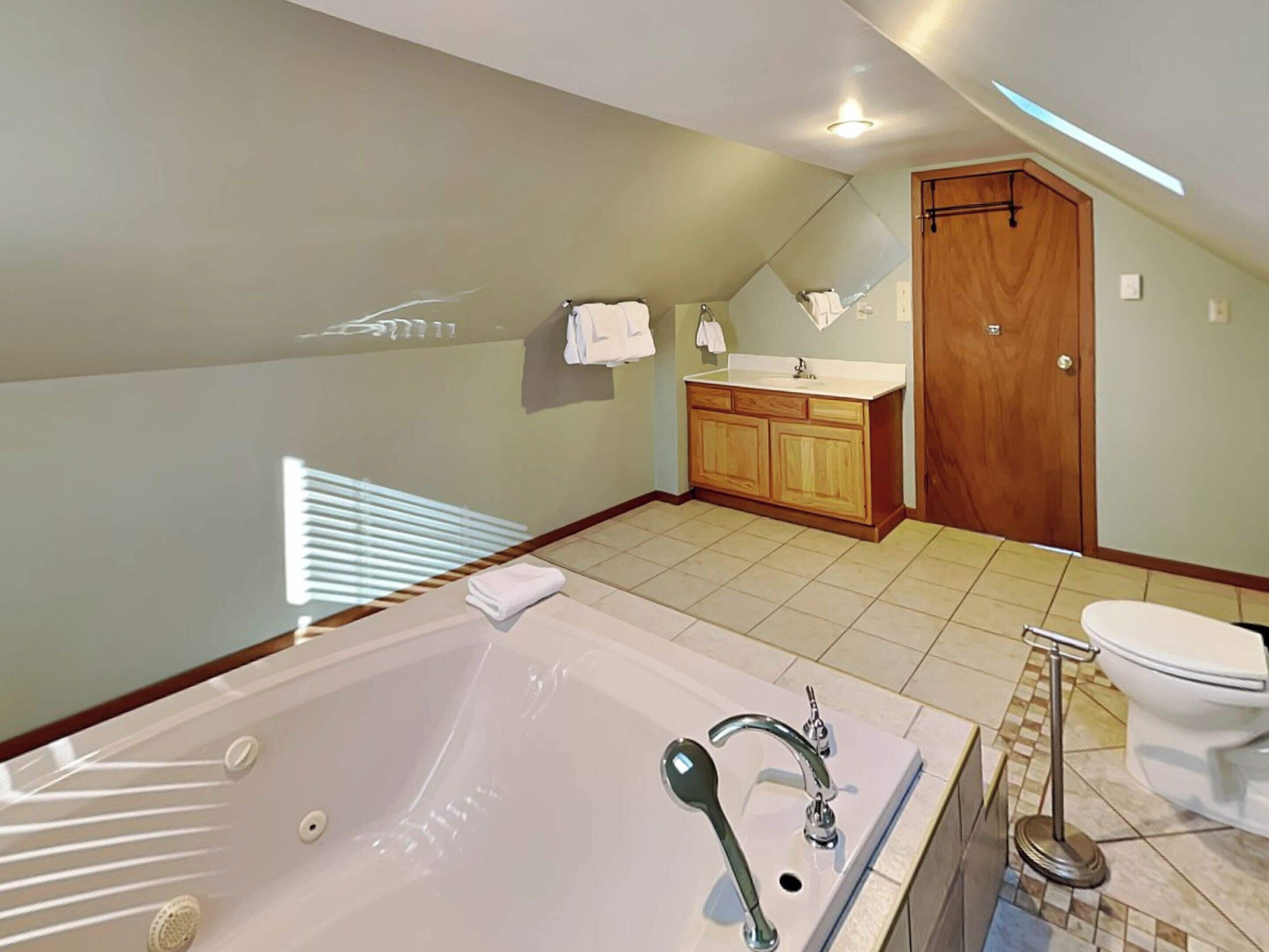 Un baño moderno con una bañera grande, un lavabo e inodoro.