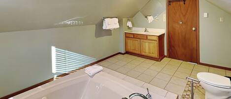 Un baño moderno con una bañera grande, un lavabo e inodoro.