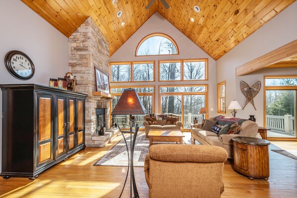 Cozy living room with a fireplace, large windows, and comfortable seating options.