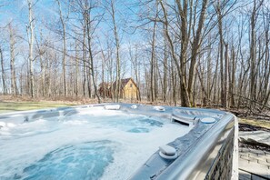 Relax in a serene outdoor hot tub surrounded by nature.