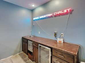 A kitchen with a wooden countertop, a built-in refrigerator, and a neon sign that reads "SPACE MOUNTAIN CHALLET". - Space Mountain by Taylor Made Deep Creek (McHenry)