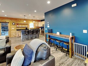 A modern interior with a kitchen, bar area, and seating. - Space Mountain by Taylor Made Deep Creek (McHenry)