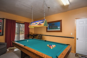 A pool table with a green felt surface, a hanging light fixture, and a Corona Extra sign on the wall. - Sparky's Lodge by Taylor Made Deep Creek (McHenry)
