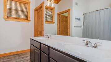 A bathroom with two sinks, wooden cabinets, and a large mirror.