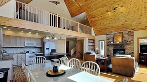 A spacious kitchen with a dining area, a living room with a fireplace, and a loft bedroom. - Sunny Boy by Taylor Made Deep Creek (McHenry)