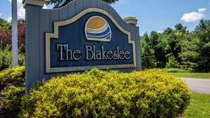 A sign for The Blakeslee with a stylized sun logo. - Sunrise by Taylor Made Deep Creek (Oakland)