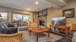 A cozy living room with a fireplace, comfortable seating, and a television.