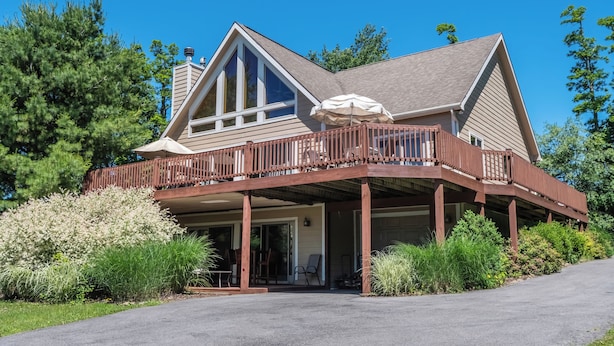 A two-story house with a covered porch, large windows, and a garage.