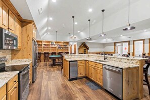 A spacious kitchen with wooden cabinets, stainless steel appliances, and a central island.
