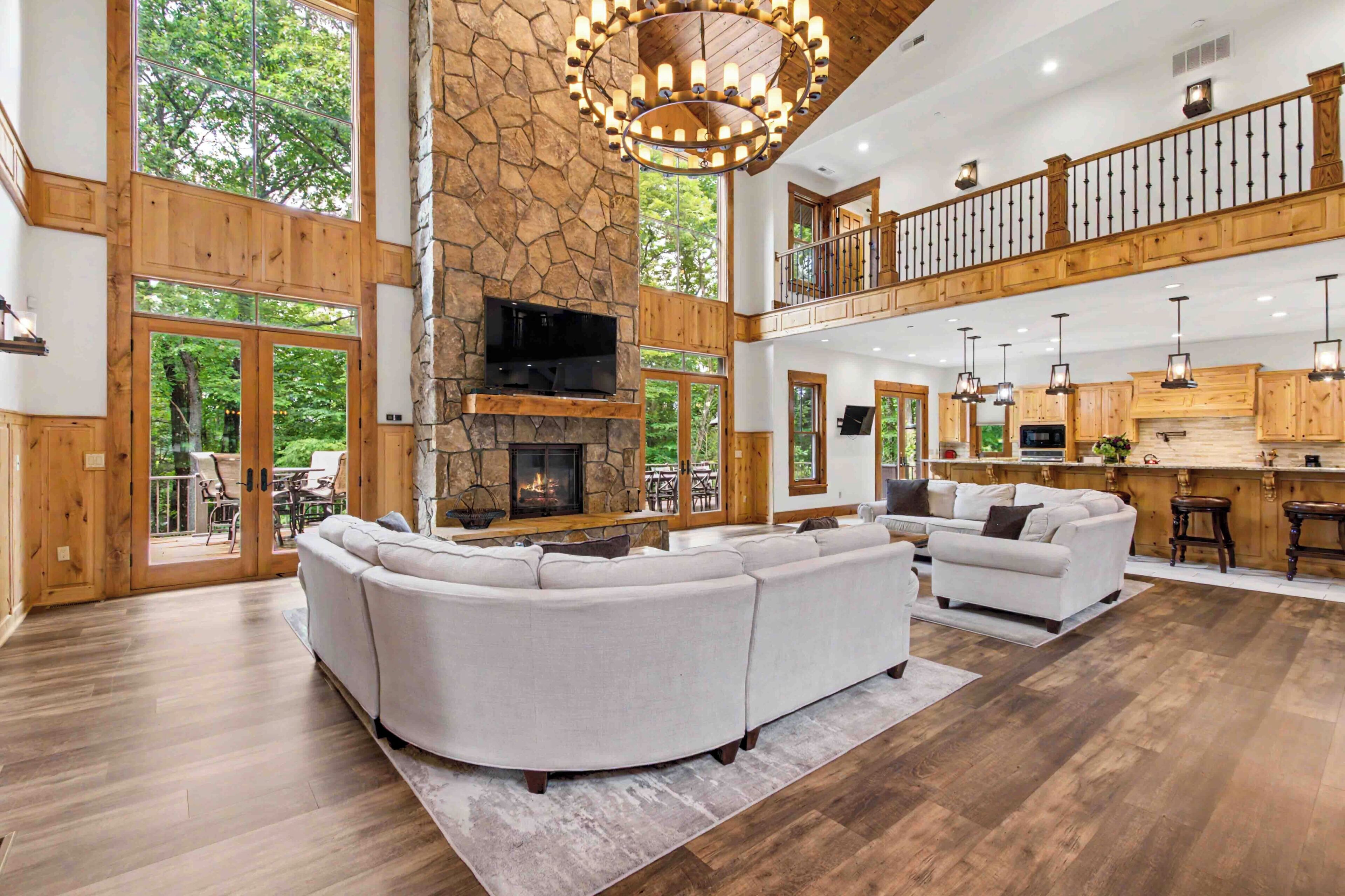 A spacious living area with a stone fireplace, a large sectional sofa, and a dining area with wooden furniture.