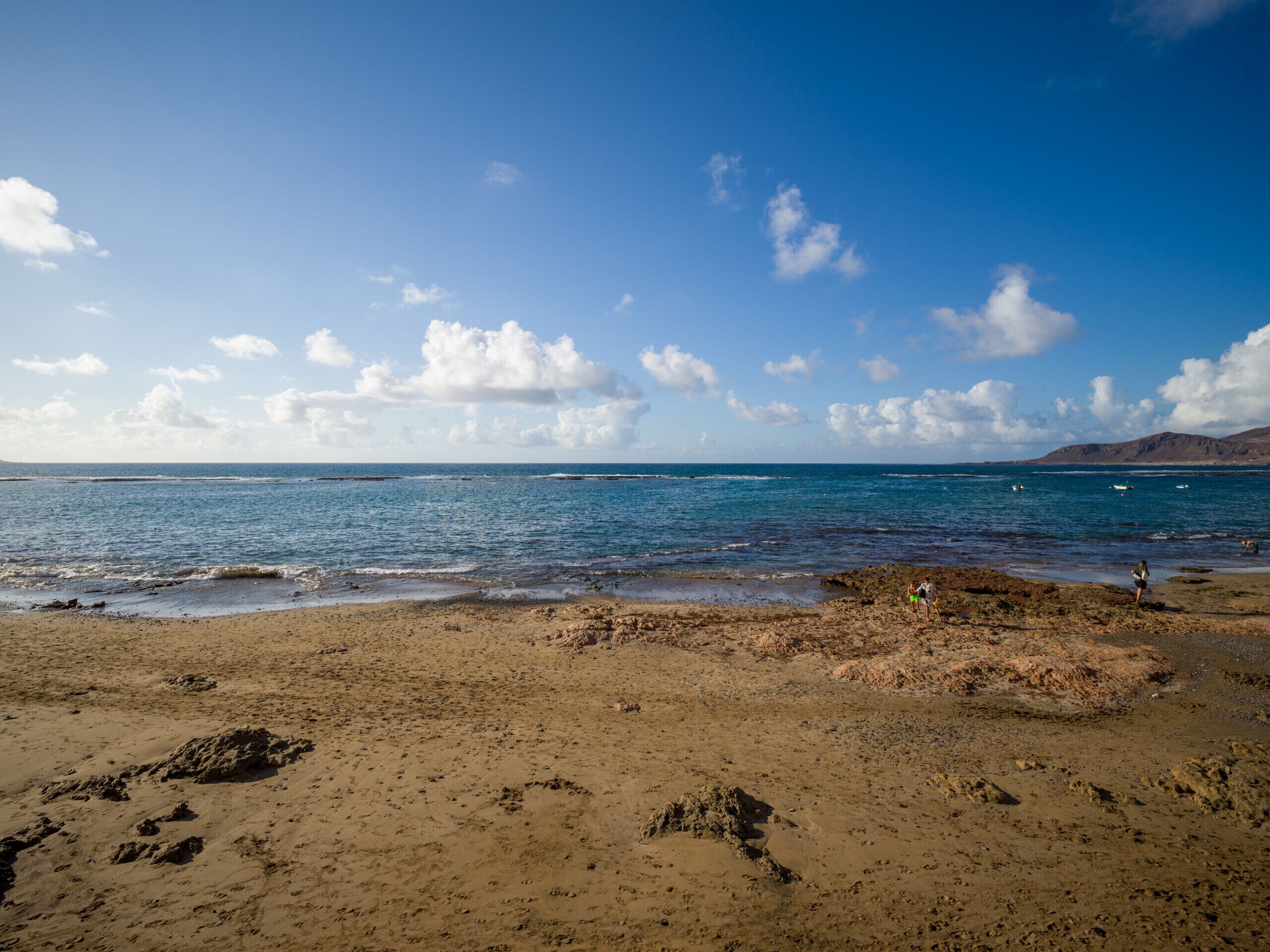 Una playa con cielos despejados y aguas tranquilas.