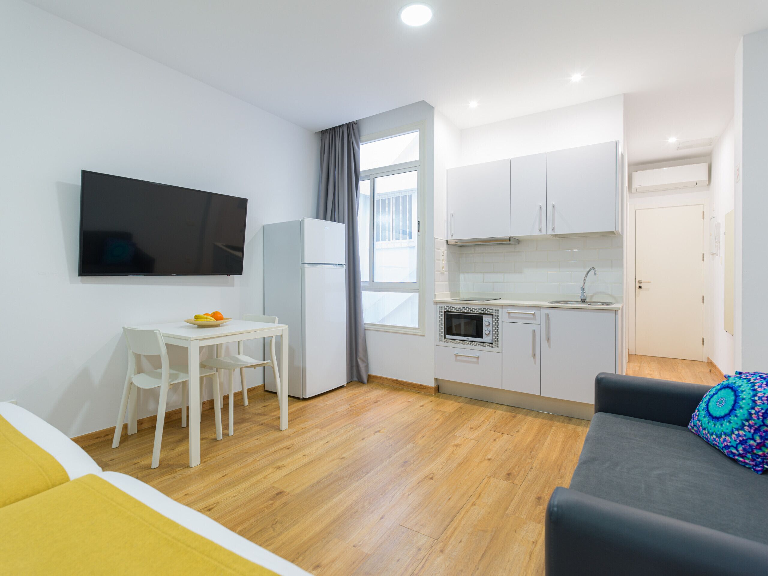 A compact living space with a kitchenette, a dining area, and a seating area.
