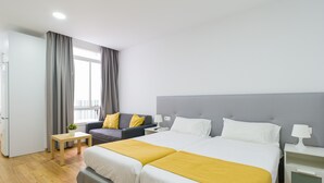 Ett hotellrum med en dubbelsäng, en soffa, ett litet bord och ett sängbord.