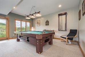 A pool table with a wooden frame, a pool cue, and a billiard ball. There is a pool table with a wooden frame, a pool cue, and a billiard ball. - Valley Lodge by Taylor Made Deep Creek (McHenry)