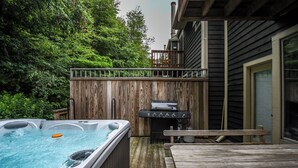 A wooden deck with a hot tub, grill, and picnic table. - Villages of Wisp 08 Winding Way by Taylor Made Deep Creek (McHenry)