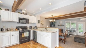 A spacious kitchen with white cabinets, a built-in microwave, and a dishwasher. - Villages of Wisp 08 Winding Way by Taylor Made Deep Creek (McHenry)
