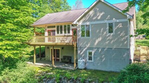 A two-story house with a balcony, a front porch, and a small attached garage. - Wake at the Lake by Taylor Made Deep Creek (Swanton)