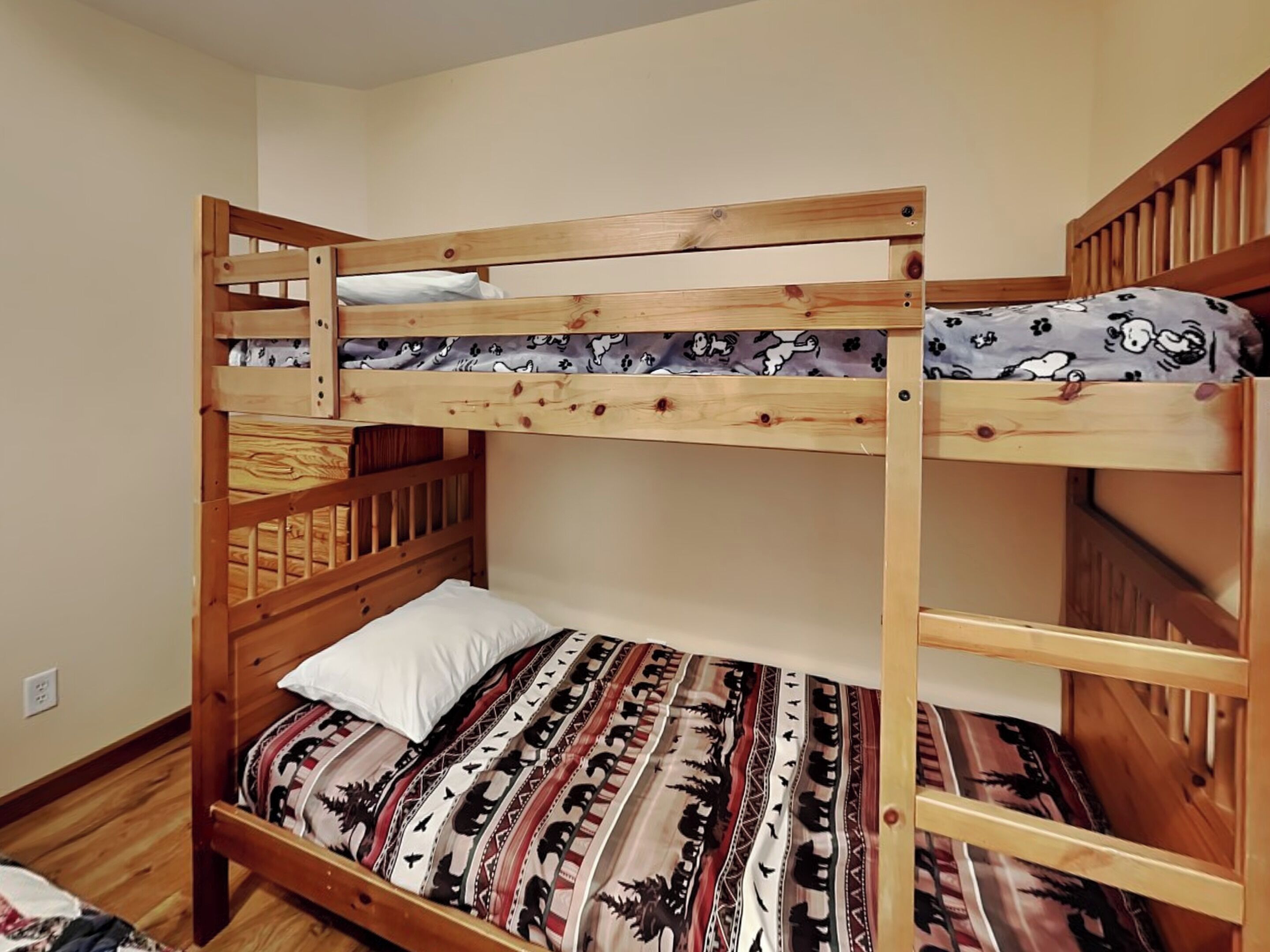 A bunk bed with a patterned bedspread and a white pillow.