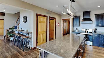 Una cocina amplia con una isla grande, pisos de madera y muebles de cocina modernos.