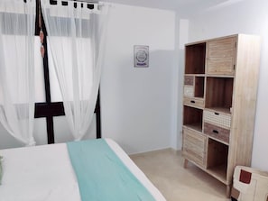 A bedroom with a bed, a wardrobe, and a wall-mounted decoration.