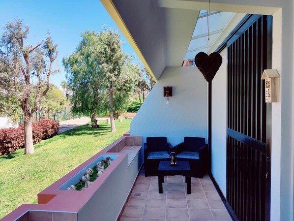 Un balcon doté d’un espace salon, d’une décoration en forme de cœur et offrant une vue sur le jardin.