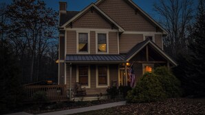 A two-story house with a front porch, a deck, and a well-maintained lawn. - Wine Down by Taylor Made Deep Creek (Oakland)