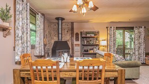 A cozy dining area with a wooden table, chairs, and a fireplace. - Woodside Retreat by Taylor Made Deep Creek (McHenry)