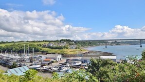A marina with boats docked, a bridge in the background, and a hilly landscape. - Marina Reach, Neyland, Pembrokeshire: Sea views (Neyland)