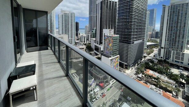 A balcony with a view of high-rise buildings and a clear sky.